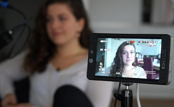 Bloggerin Morena Diaz sitzt im Wohnzimmer und vor ihr steht das Handy im Filmmodus auf einem Stativ