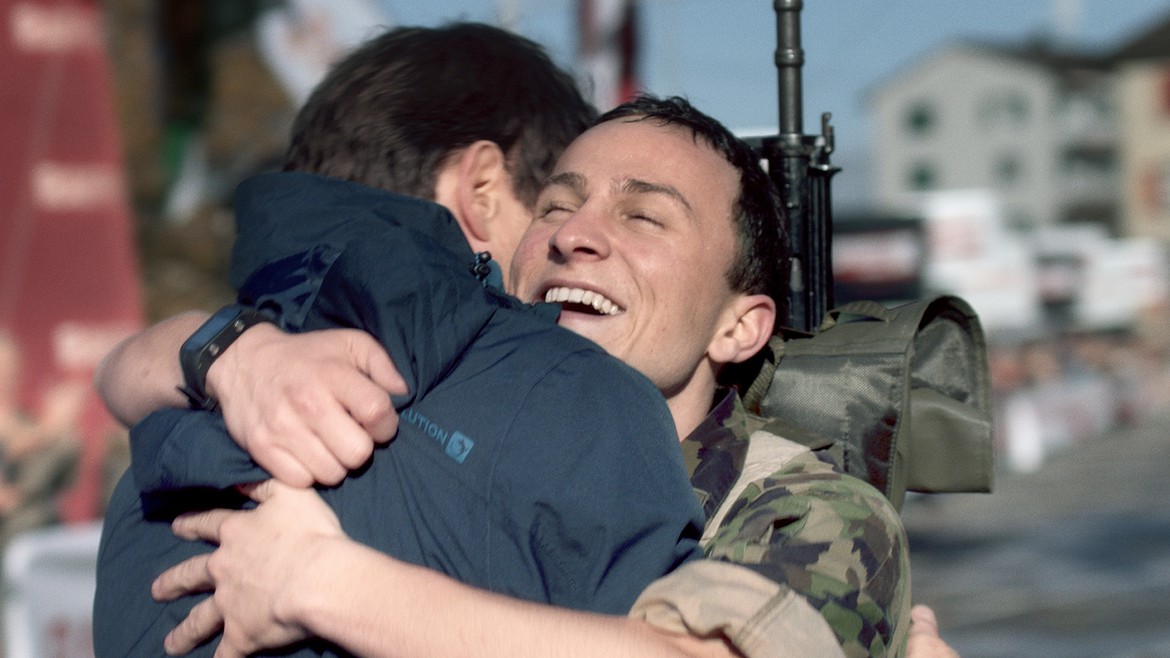 Still aus «Der Läufer», Schweizer Soldat umarmt seinen Vater und lächelt