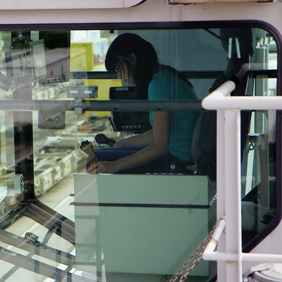 Eine Frau sitzt in der Fahrerkabine eines Paket-Krans der Post