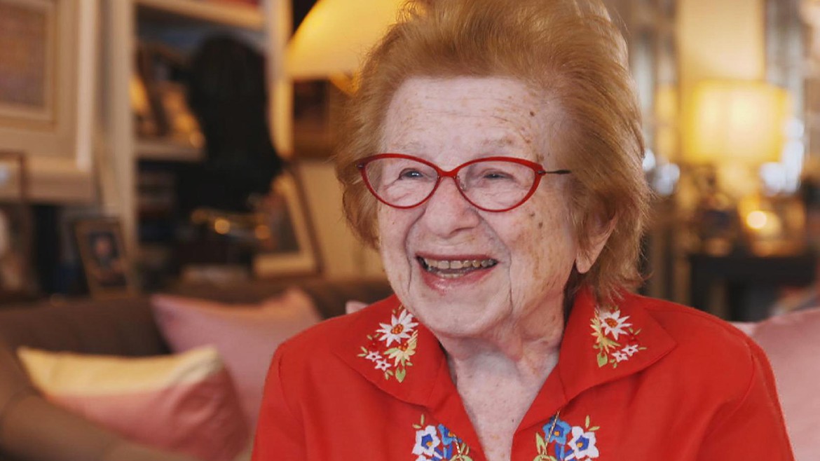 Die 91-jährige Sexualtherapeutin «Dr.Ruth» sitzt in ihrem Wohnzimmer und lächelt in die Kamera