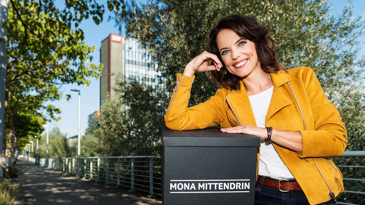 Mona steht vor dem Fernsehstudio in Leutschenbach und hält eine Überraschungsbox in der Hand