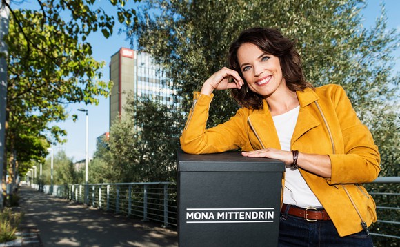 Mona steht vor dem Fernsehstudio in Leutschenbach und hält eine Überraschungsbox in der Hand