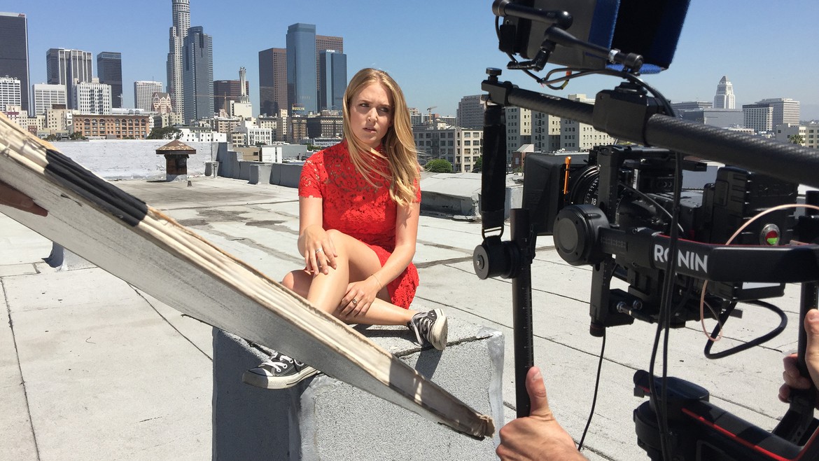 Sabrina Kern sitzt in einem roten kleid auf einem Hochhaus in Los Angeles