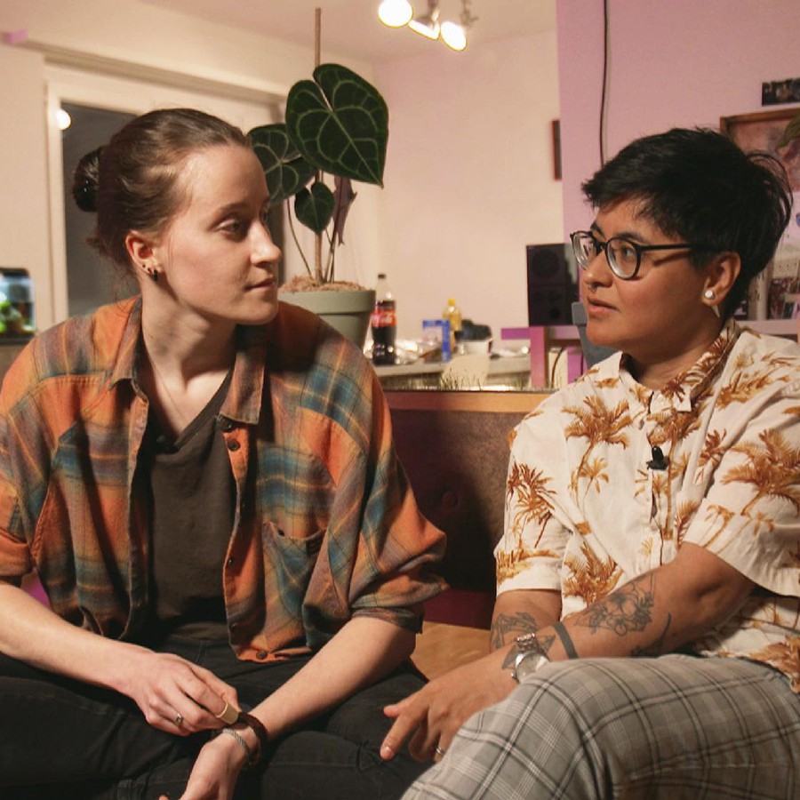 Ein lesbisches Paar sitzt zuhause auf dem Sofa