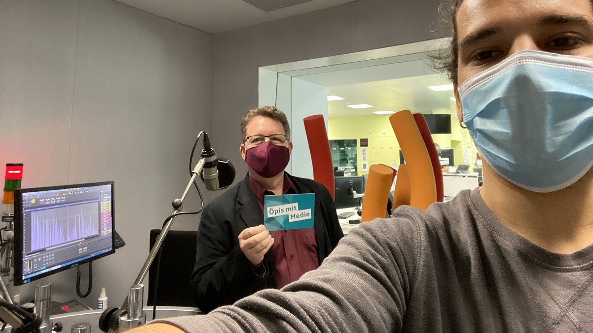 Praktikant Jan steht mit Philip Meyer im Radiostudio. Beide tragen Mundschutz und halten Abstand.