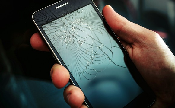 Jemand hält ein Smartphone mit einem zerbrochenen Bildschirm in der Hand