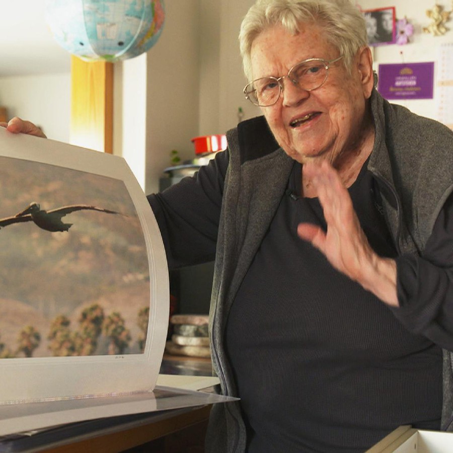 Die 87-jährige Liva Tresch zeigt auf ein Foto, auf welchem ein Vogel abgelichtet ist