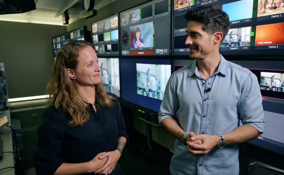 Tobias Müller und Natasha Ruf stehen nebeneinander in der TV-Regie und schauen sich an