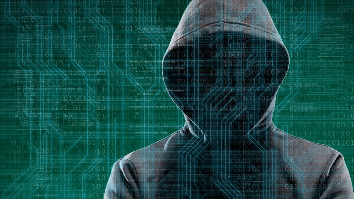 Ein vermummter Hacker mit Programmiercodes im Hintergrund